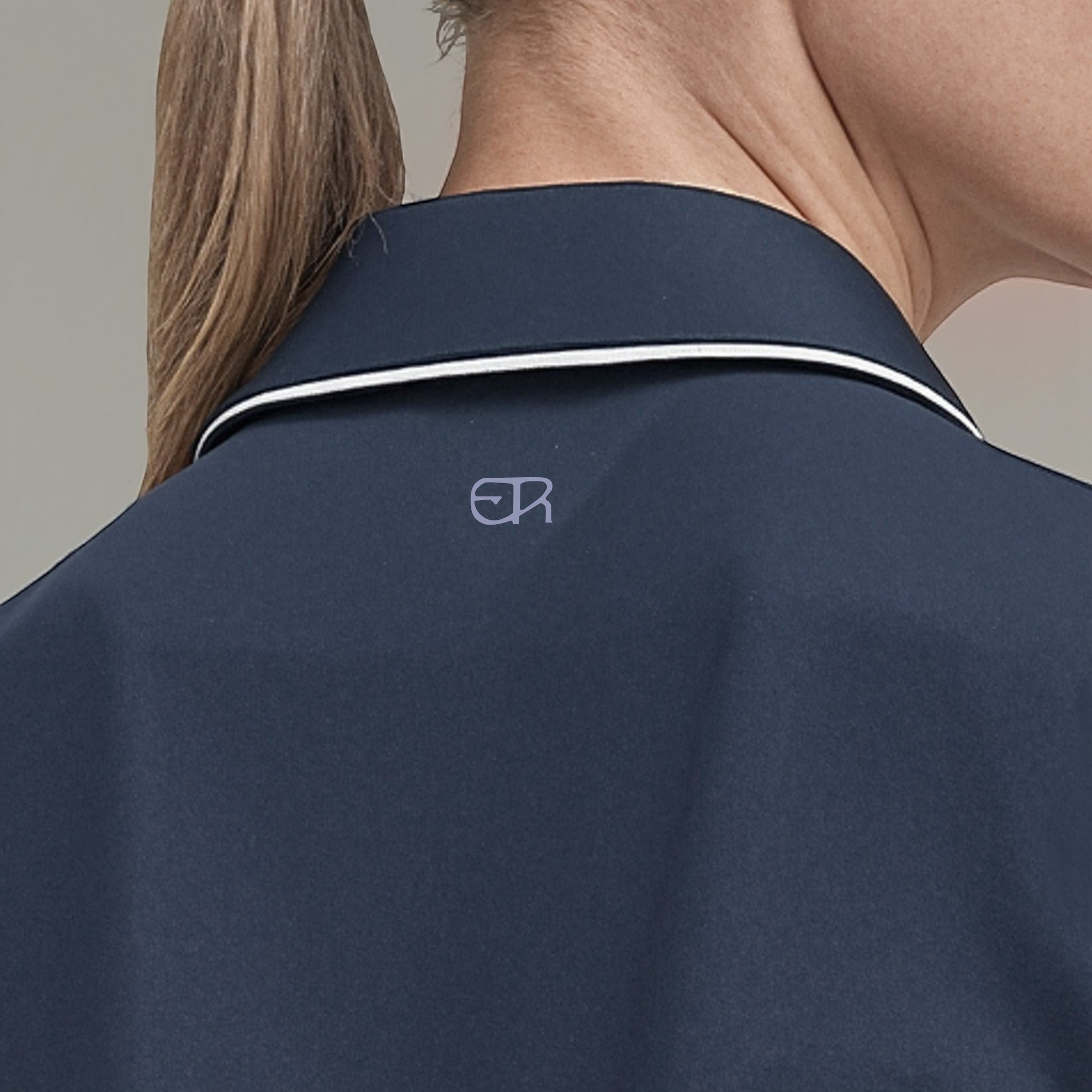 Elliott & Rose navy performance golf polo shirt with white trim and embroidered logo on back.