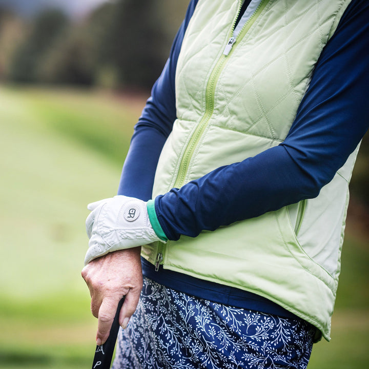 Elliott & Rose navy quarter zip pullover with green trim, layered under a light green quilted vest, for golf.