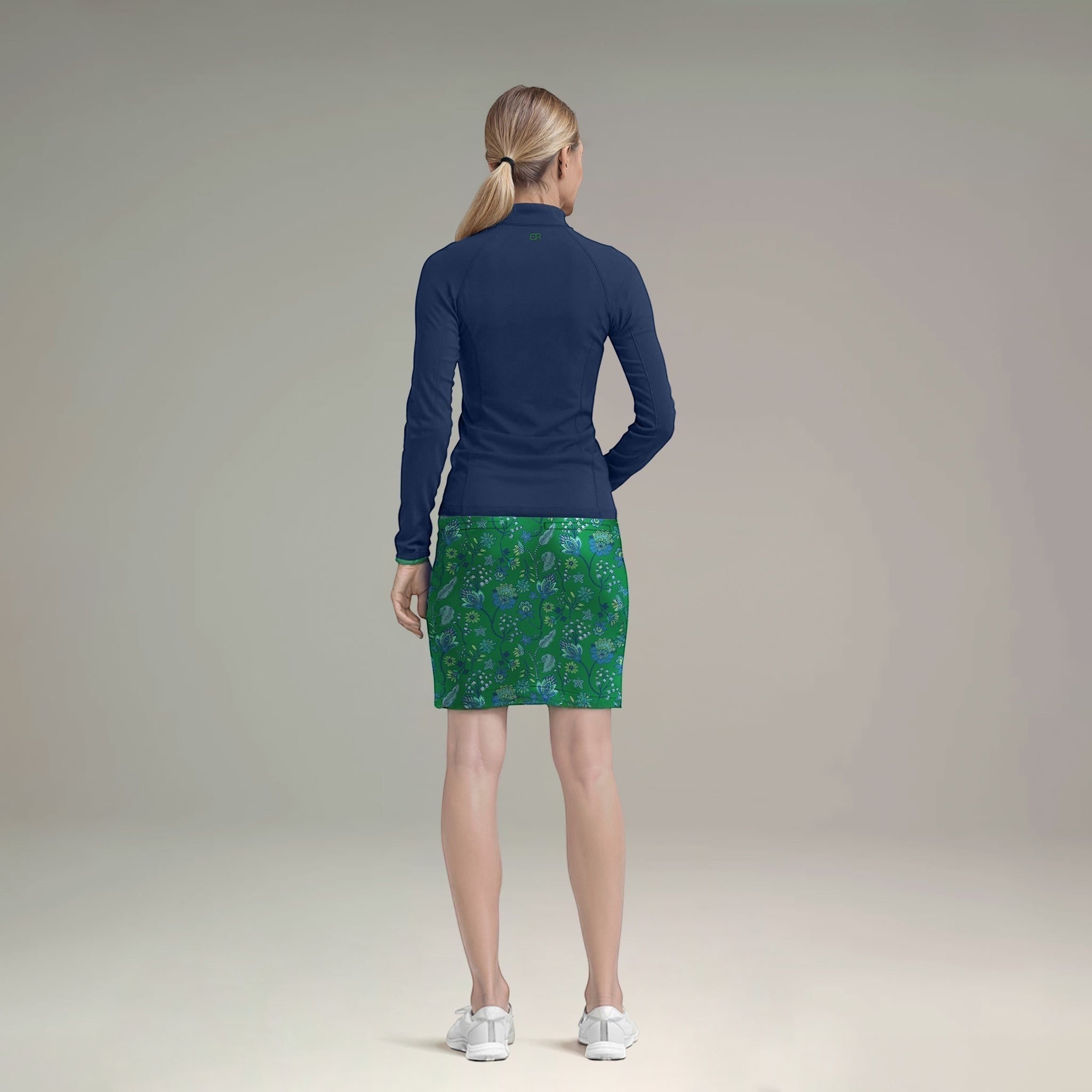 Elliott & Rose navy quarter zip pullover with green floral print skirt. Breathable, lightweight fabric, quarter-zip neckline, long sleeves.