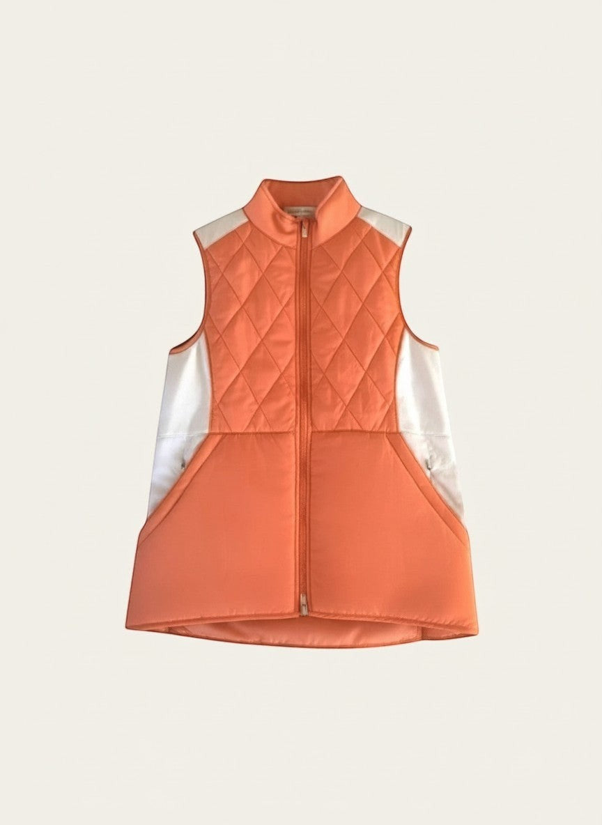 Elliott & Rose quilted tangerine golf vest with white side panels, full-zip front, and diamond-quilted pattern.